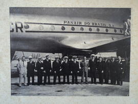 Fotografia (reprodução mecânica) de grupo de tripulantes da Panair (13 homens) com aeronave ao fundo
